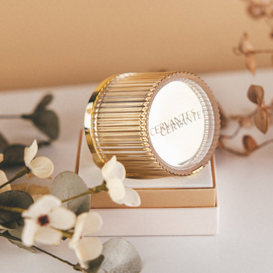 Elegantna zlato obarvana embalaža CERVANTES pomlajevalne kreme proti gubam, luksuznega anti-age izdelka z biotehnološko formulacijo, predstavljena na čistem, minimalističnem ozadju.